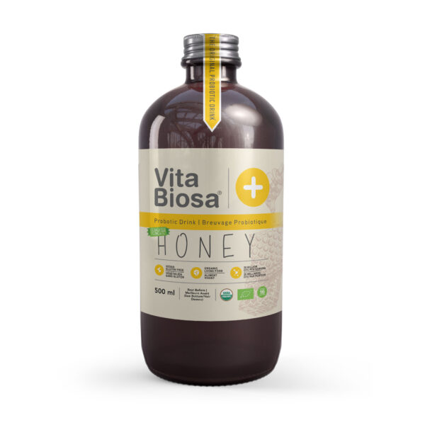 Bottle of Vita Biosa Honey Tea surrounded by tea leaves and honeycomb, highlighting its natural ingredients and refreshing appeal.